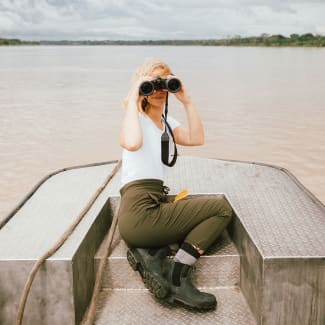A woman with binoculars on a skiff