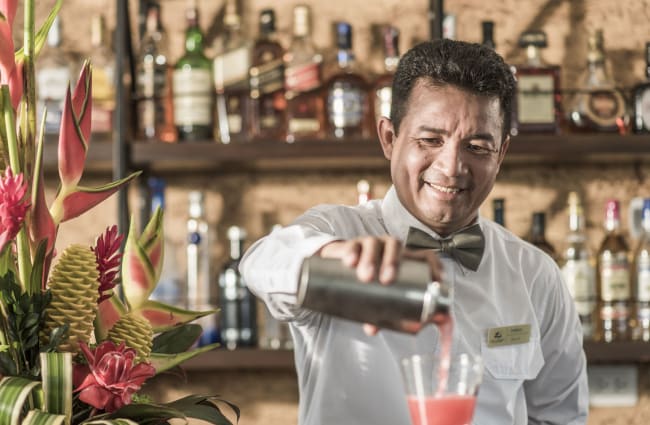 Smiling bartender pouring a drink